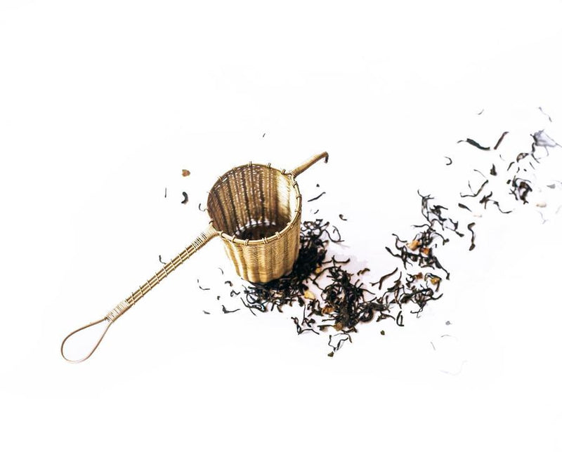 This beautiful and practical tea basket can fit in a mug or tea pot. Due to its depth, you can fill it all the way to the top for a larger pour (for tea pots) or half way for a single dose. Its double handles rest gently on the rim and can be used to brew or strain loose-leaf tea, flowers, and more. Over time, the brass will acquire a rich patina. Hand woven in India. 