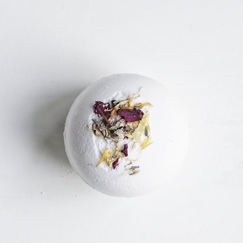 A super moisturizing, fizzing, floral bath experience all in one little bomb. Powered with shea butter and lavender essential oils. Add to a warm bath. Remove and allow to completely dry out for future uses. Ingredients: Shea Butter, Sodium Bicarbonate, Citric Acid, Lavender Essential Oil, flower petals.
